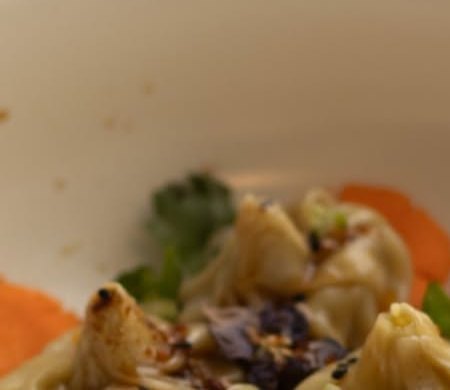 Dumplings servidos con zanahoria y hierbas