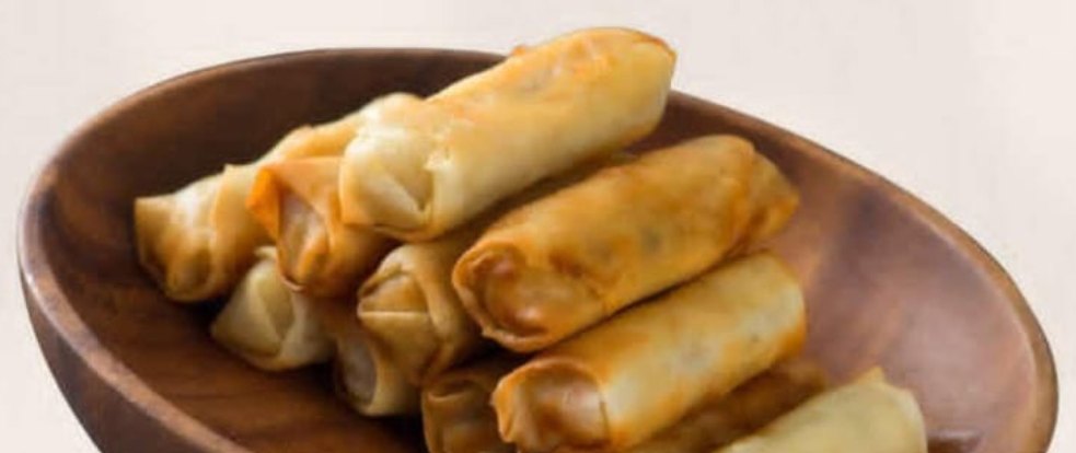Spring rolls dorados en un plato de madera